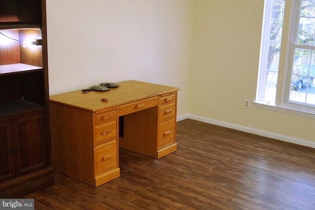 unfurnished office with dark wood-type flooring and baseboards