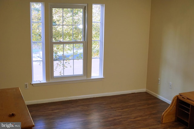 empty room with dark wood finished floors and baseboards