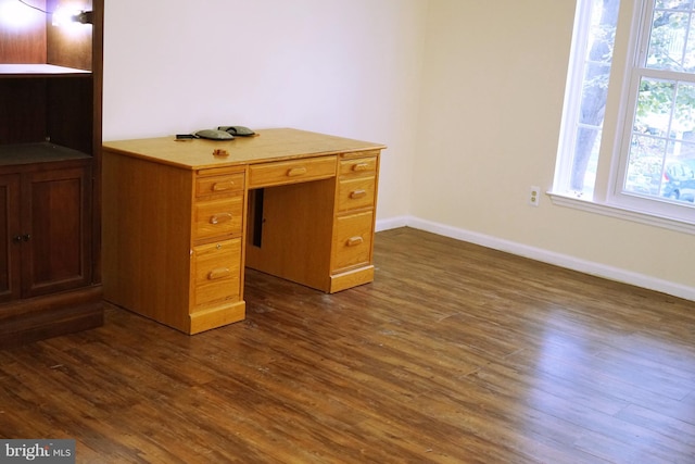 unfurnished office featuring dark wood-style floors and baseboards