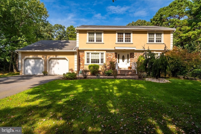 colonial inspired home featuring driveway, a front lawn, an attached garage, and stucco siding