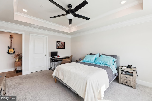 bedroom with baseboards, a raised ceiling, carpet floors, and crown molding