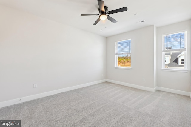 empty room with visible vents, baseboards, light colored carpet, and ceiling fan