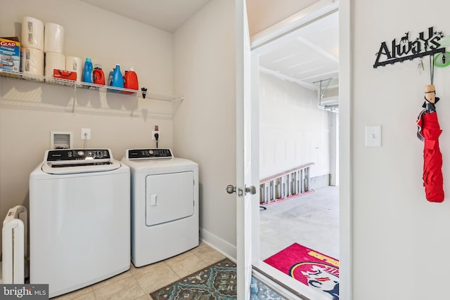 laundry area with washer and clothes dryer, radiator, light tile patterned floors, baseboards, and laundry area