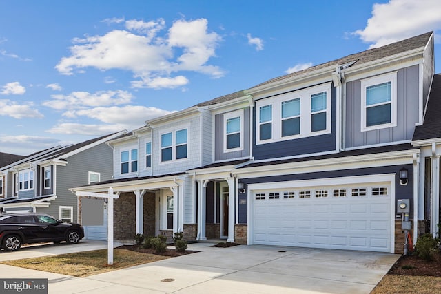 view of front of home with stone siding, board and batten siding, concrete driveway, and an attached garage