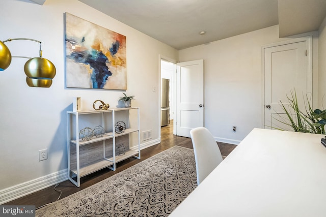 office space featuring dark wood-type flooring, visible vents, and baseboards