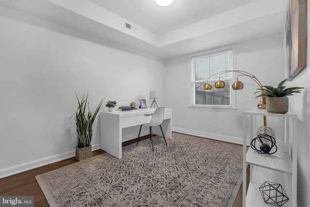 office area with visible vents, baseboards, and wood finished floors