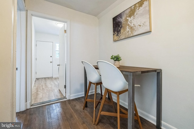 dining area with wood-type flooring and baseboards