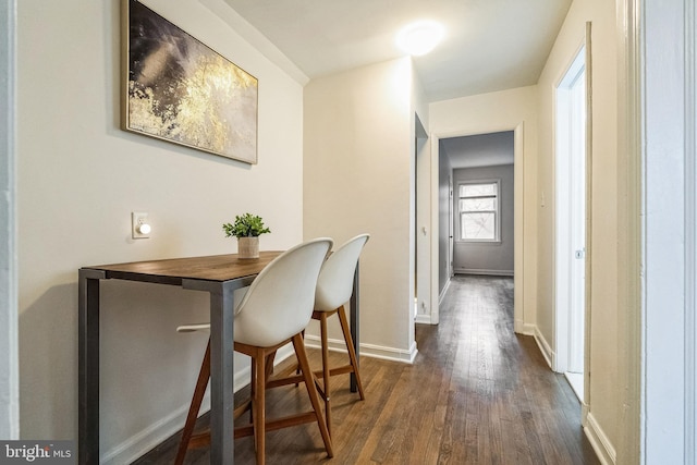 dining room featuring dark wood finished floors and baseboards