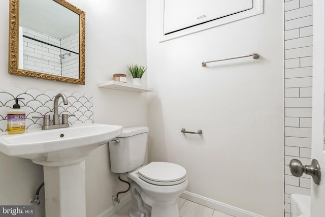 full bath with toilet and baseboards