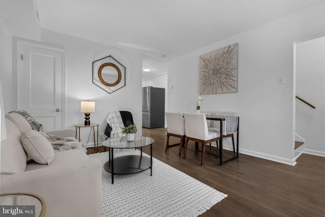 living area with stairway, baseboards, and wood finished floors