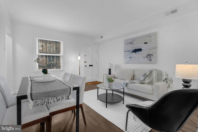 living area with visible vents and wood finished floors