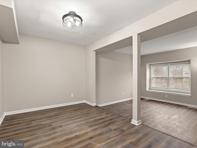 below grade area with dark wood-type flooring and baseboards