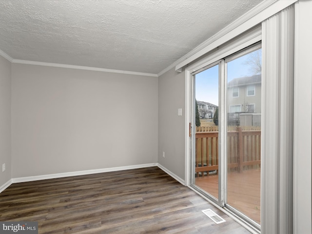 empty room with a textured ceiling, visible vents, baseboards, dark wood-style floors, and crown molding