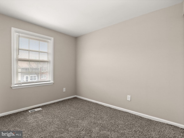 carpeted empty room featuring baseboards and visible vents