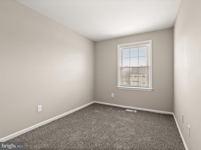 carpeted empty room with visible vents and baseboards