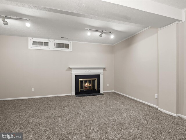 unfurnished living room featuring a fireplace with flush hearth, carpet flooring, a textured ceiling, and baseboards