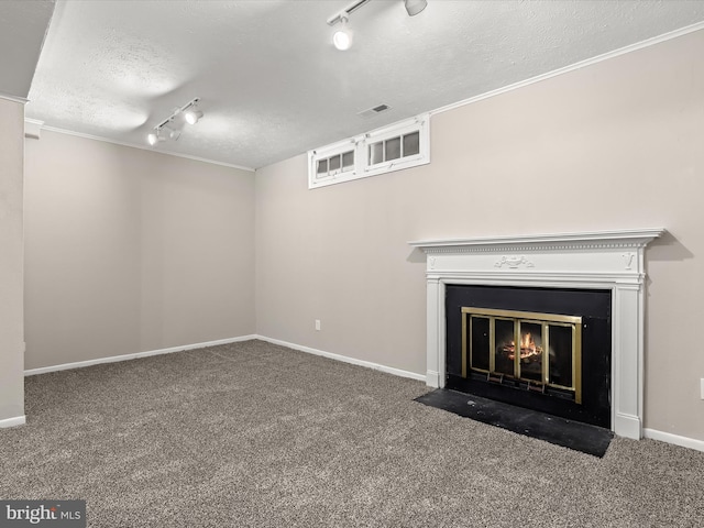 unfurnished living room featuring a textured ceiling, carpet floors, a fireplace with flush hearth, visible vents, and baseboards