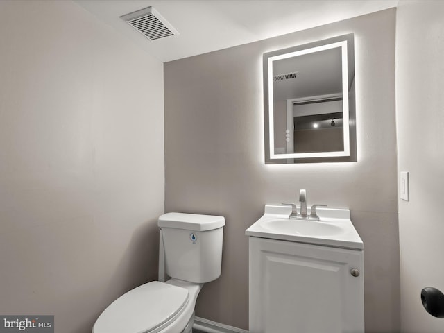 half bathroom with toilet, visible vents, and vanity