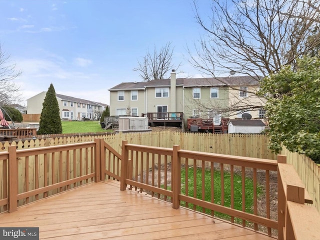 wooden deck with a fenced backyard, a residential view, and a lawn