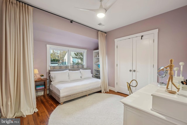 bedroom with ceiling fan, visible vents, a closet, and wood finished floors