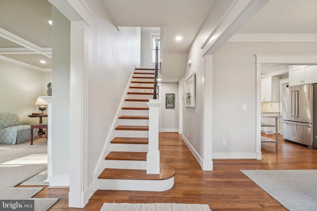 stairway with recessed lighting, baseboards, hardwood / wood-style floors, and ornamental molding