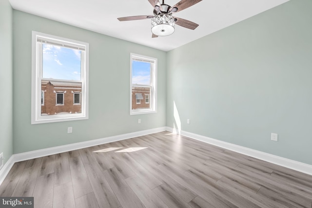 unfurnished room featuring a ceiling fan, baseboards, and wood finished floors