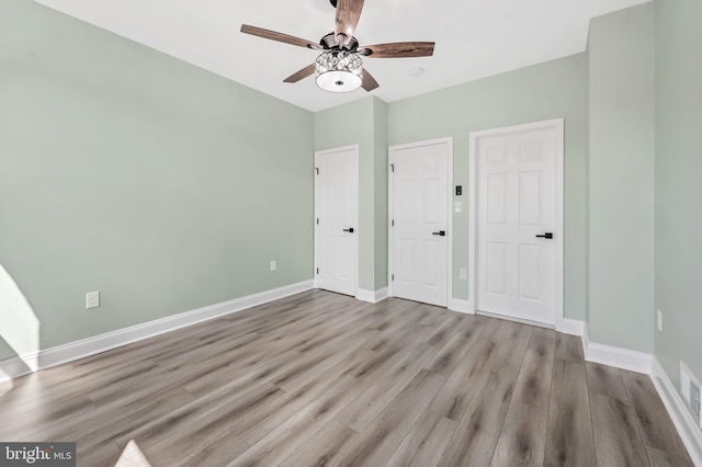 unfurnished bedroom featuring ceiling fan, baseboards, and wood finished floors