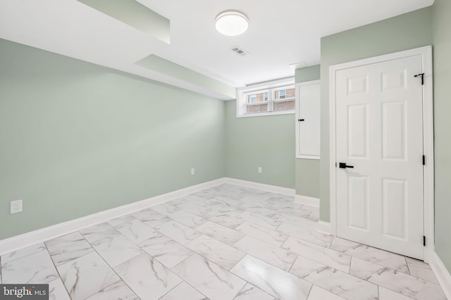 spare room featuring marble finish floor, visible vents, and baseboards