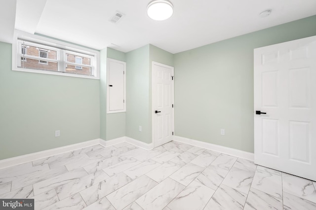 unfurnished bedroom featuring marble finish floor, visible vents, and baseboards