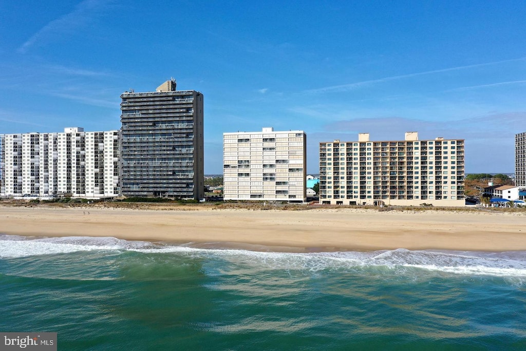 drone / aerial view with a water view, a city view, and a view of the beach