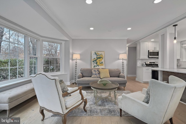 living room featuring ornamental molding, recessed lighting, light wood-style flooring, and baseboards