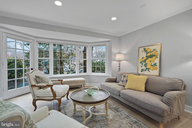 living area with baseboards, ornamental molding, recessed lighting, and light wood-style floors