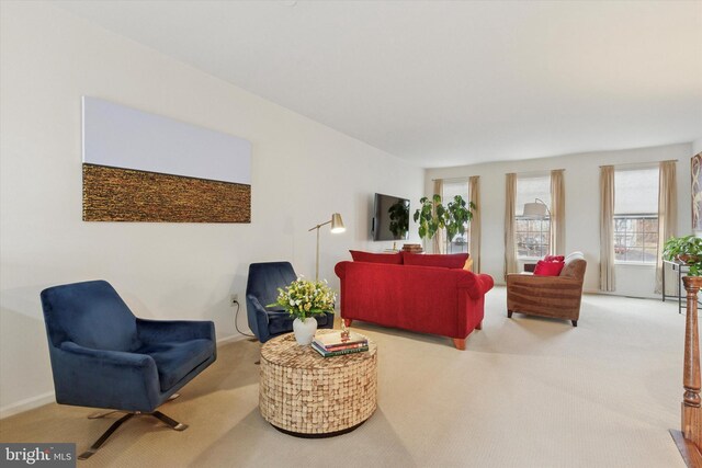 carpeted living room featuring baseboards