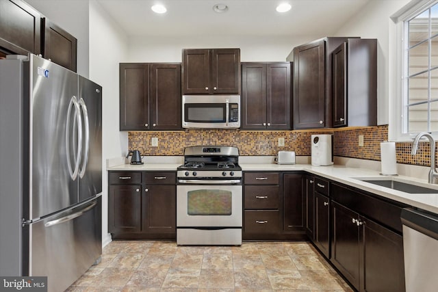 kitchen featuring light countertops, appliances with stainless steel finishes, a sink, and dark brown cabinets