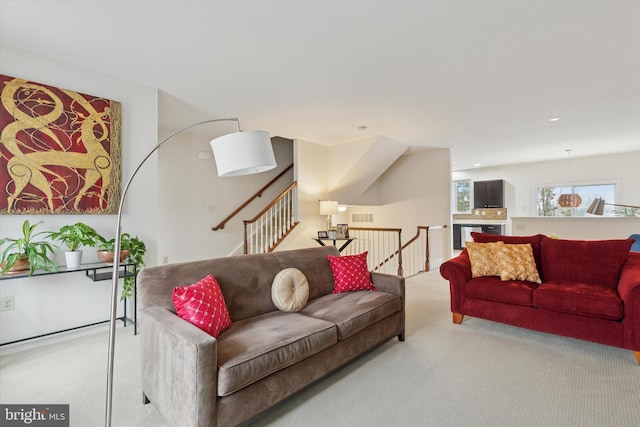 carpeted living room with stairs, visible vents, and recessed lighting