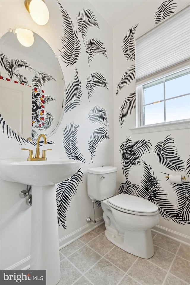 bathroom with toilet, tile patterned flooring, and baseboards