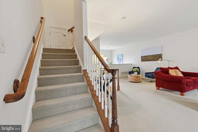 staircase featuring carpet flooring and visible vents