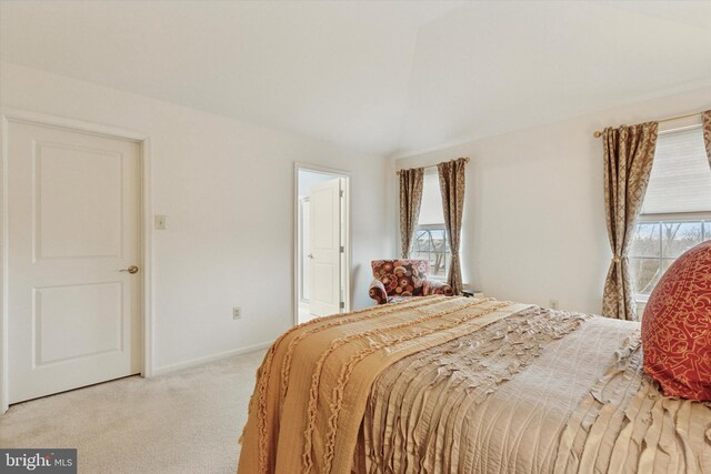 bedroom with light carpet and baseboards