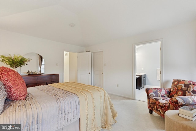 carpeted bedroom featuring ensuite bathroom and baseboards