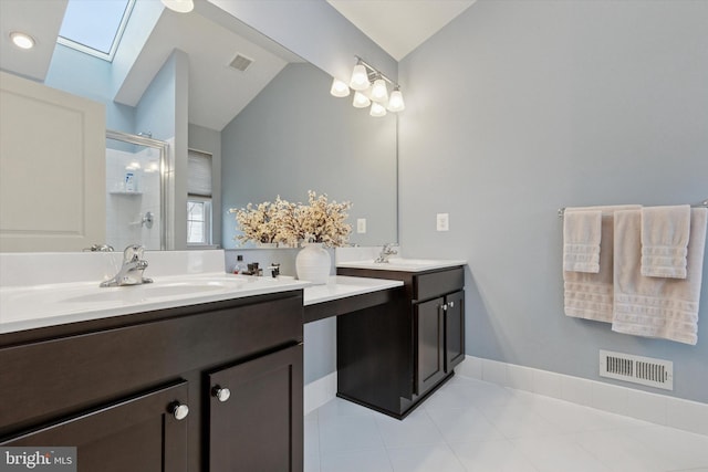 bathroom with a sink, lofted ceiling with skylight, a shower stall, and visible vents