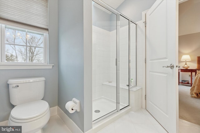 full bathroom with toilet, a stall shower, baseboards, and tile patterned floors