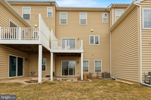 rear view of property featuring a lawn and central AC