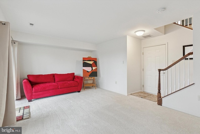 sitting room with carpet, visible vents, and stairway