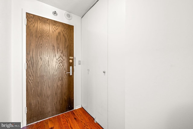 doorway to outside featuring a textured ceiling and wood finished floors