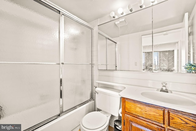 bathroom with shower / bath combination with glass door, vanity, and toilet