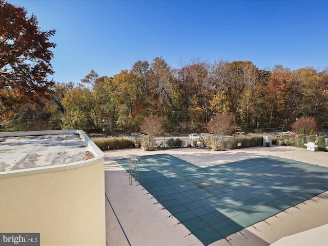 view of swimming pool featuring a patio and fence