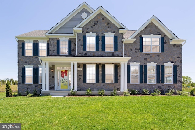 colonial inspired home with stone siding and a front lawn