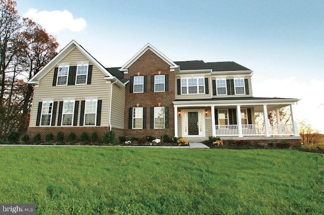 view of front facade featuring a porch, brick siding, and a front lawn