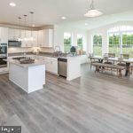 kitchen featuring dark wood-type flooring, a center island, pendant lighting, and white cabinetry