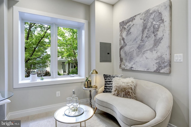 sitting room featuring electric panel, baseboards, and wood finished floors